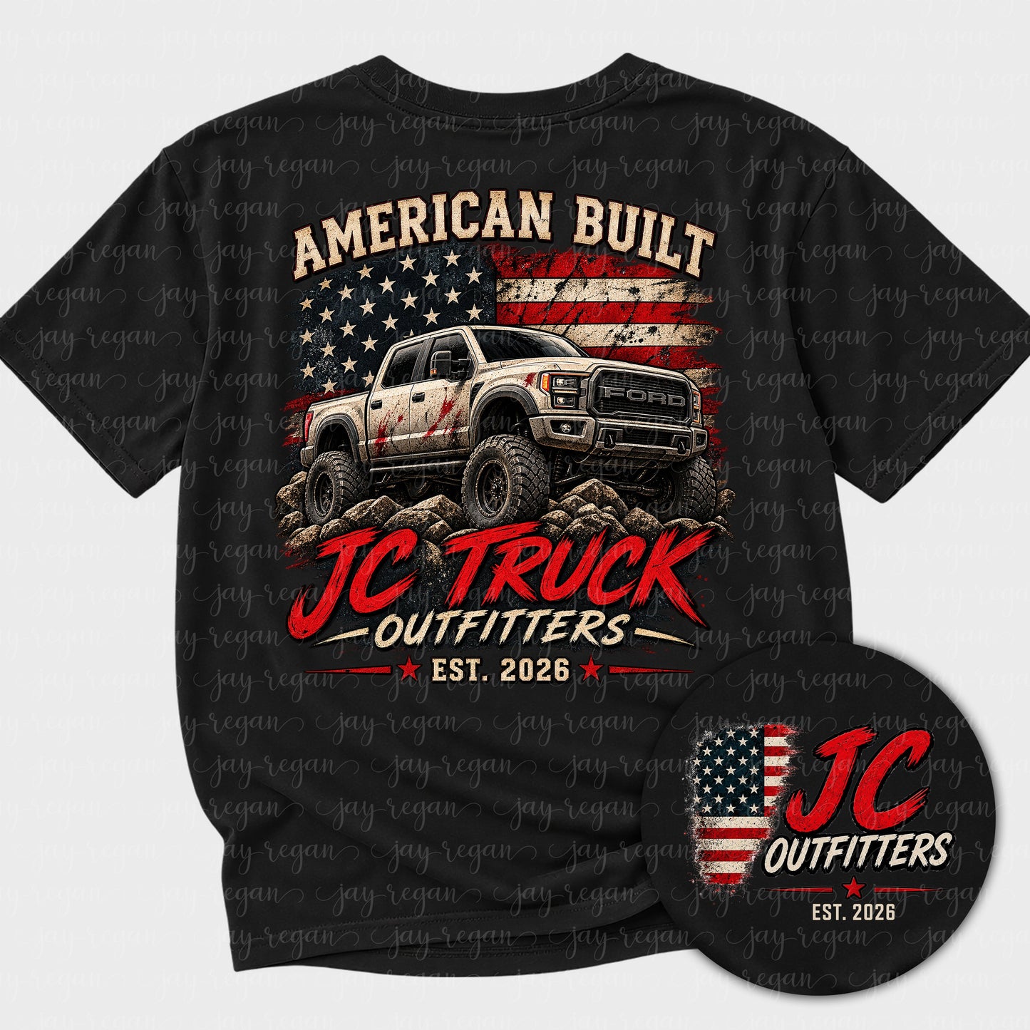 Black t-shirt with a full-back print: a lifted pickup on rocky ground in front of a distressed American flag, with the JC Truck Outfitters logo and EST. 2026 beneath it, above the words American Built.